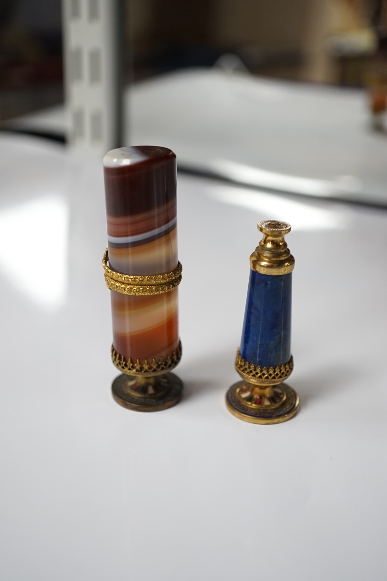 A 19th century agate and gilt metal table seal with gilt snake decoration and a smaller lapis lazuli seal, tallest agate seal 7cm high (2). Condition - fair